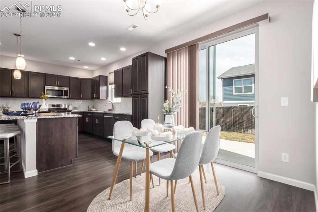 7956 Osage Street Denver, CO 80221 - Photo 9 of 48 Dining room with dark wood-type flooring, recessed lighting, and a chandelier