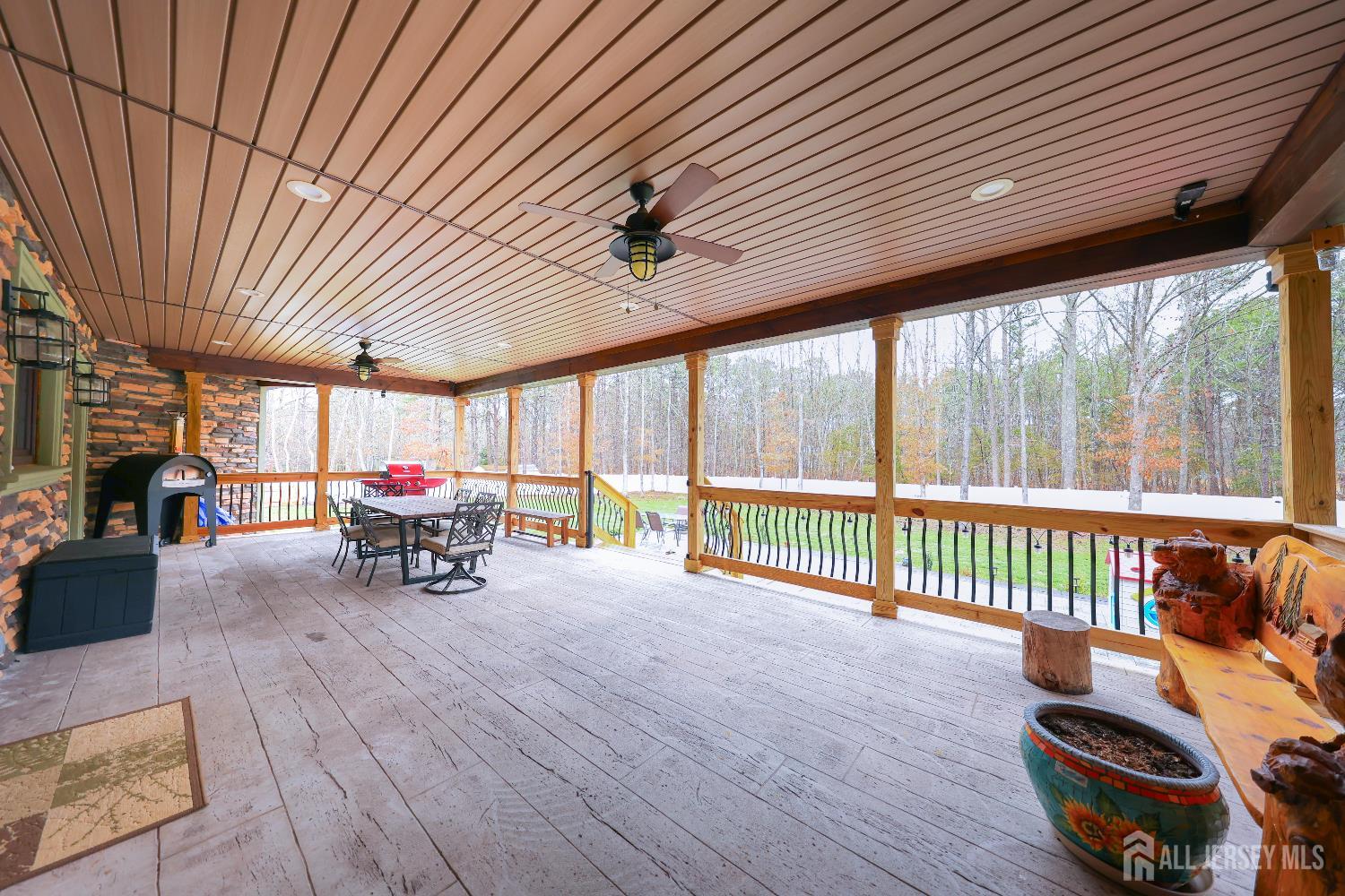 94 East Pleasant Grove Road Jackson, NJ 08527 - Photo 49 of 59 a view of a patio with table and chairs with wooden floor and fence
