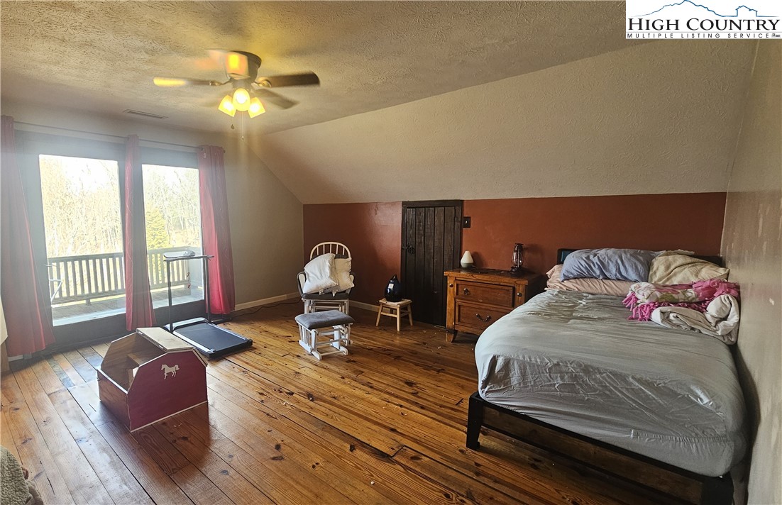 480 Schoolhouse Ridge Boone, NC 28607 - Photo 25 of 47 a living room with a bed furniture and a chandelier