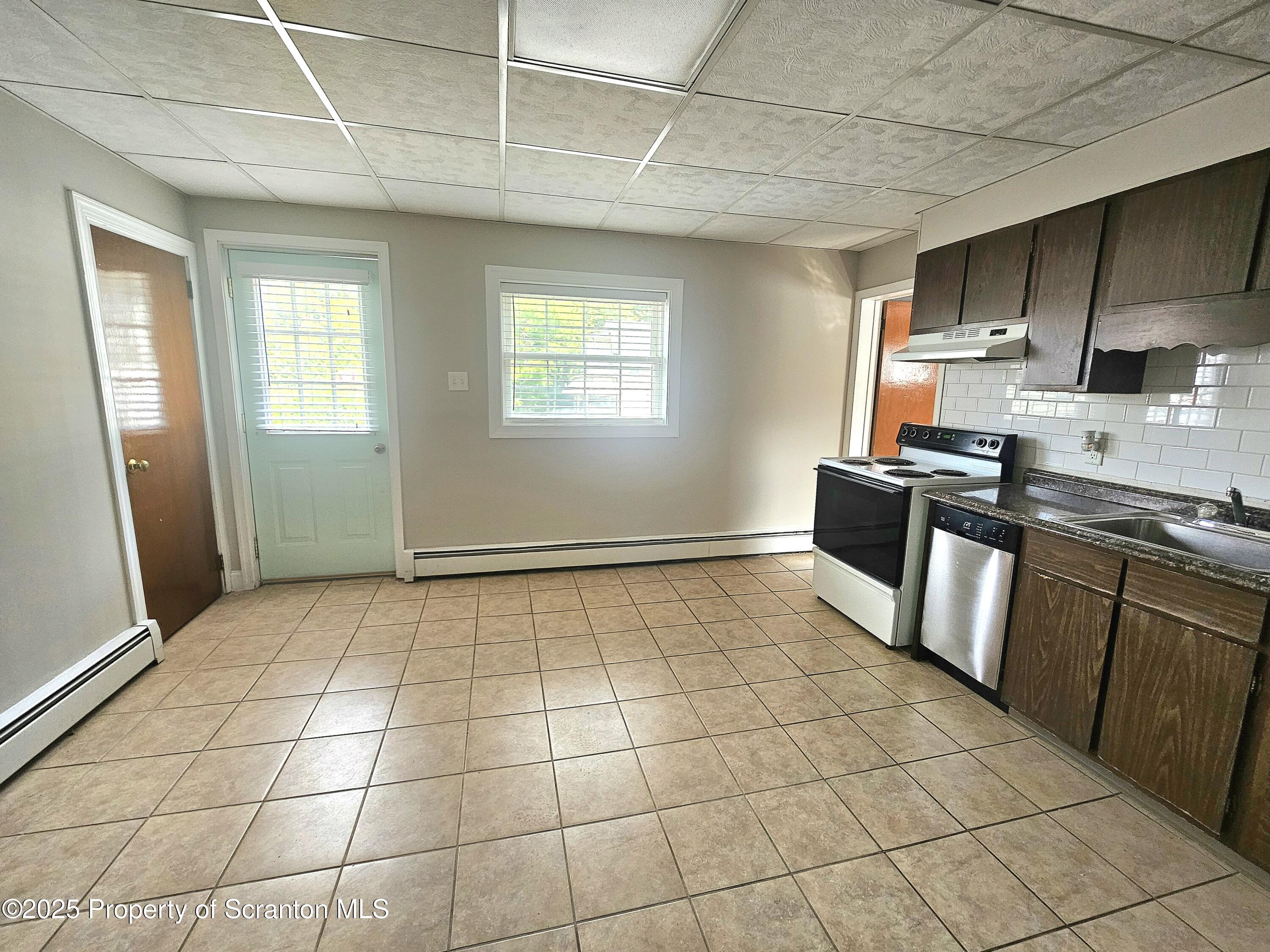 16 Swallow Street, Unit 1 Pittston, PA 18640 - Photo 3 of 14 a kitchen with granite countertop a stove a sink and a refrigerator