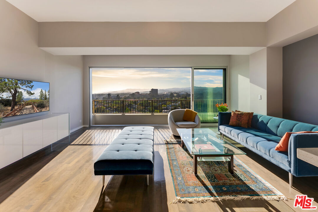 a living room with furniture and a floor to ceiling window