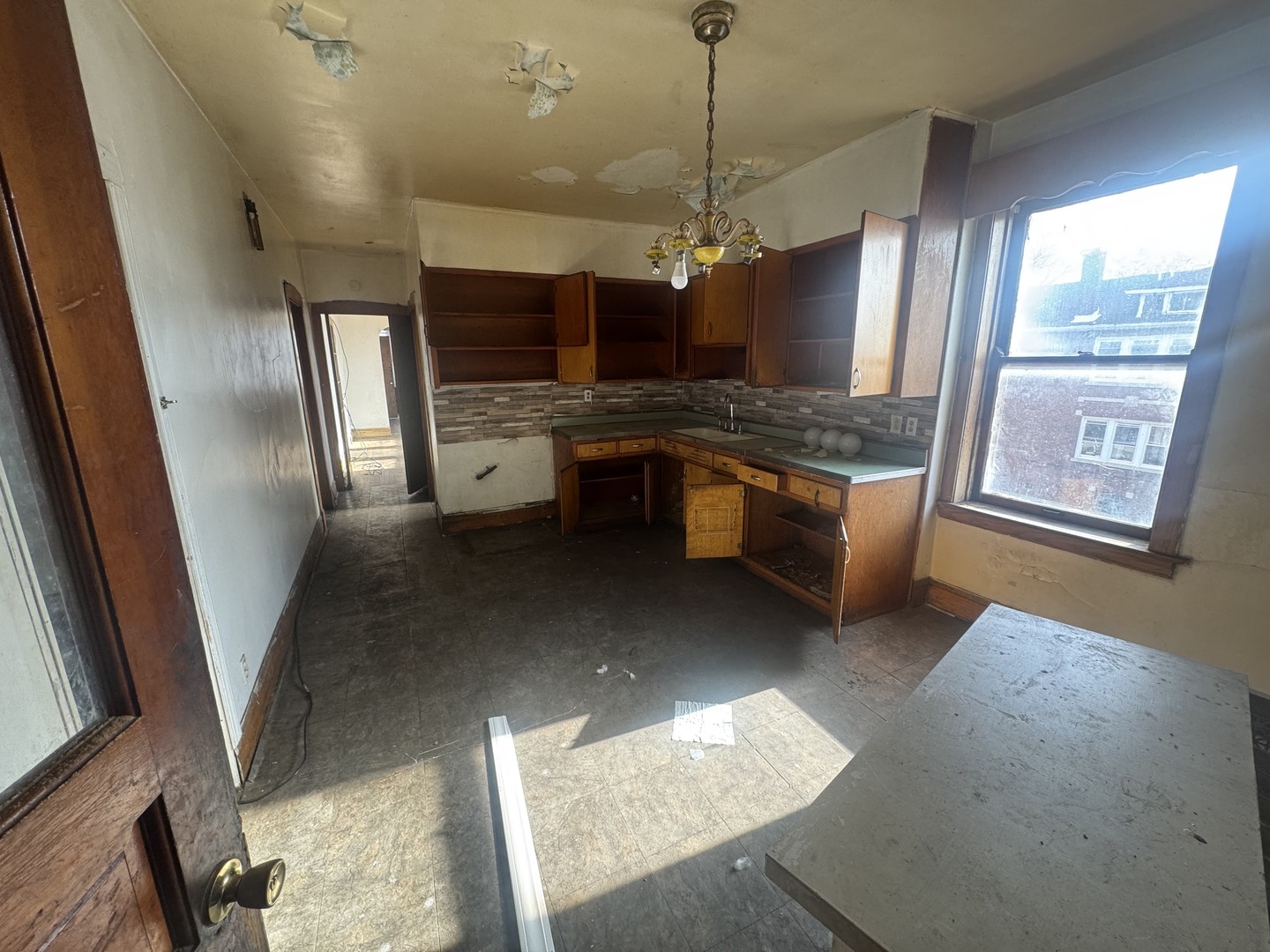 1838 48th Court Cicero, IL 60804 - Photo 11 of 13 a large kitchen with stainless steel appliances granite countertop a stove a refrigerator a sink a dining table and chairs with wooden floor