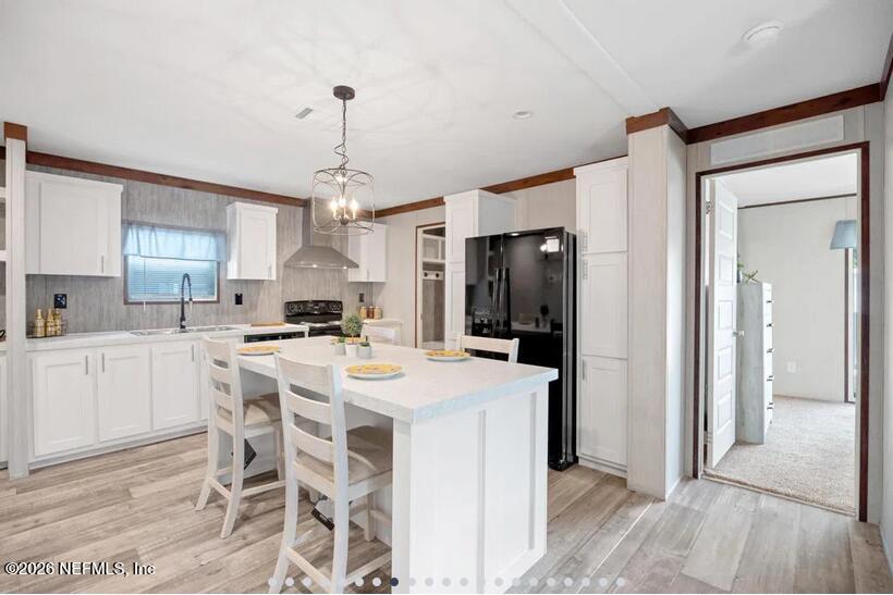 140 Islander Road Satsuma, FL 32189 - Photo 4 of 11 a kitchen with stainless steel appliances a dining table chairs and refrigerator