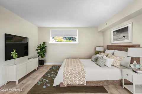 a bedroom with a large bed and a flat screen tv