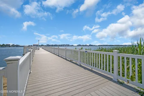 a view of a balcony with wooden floor & fence