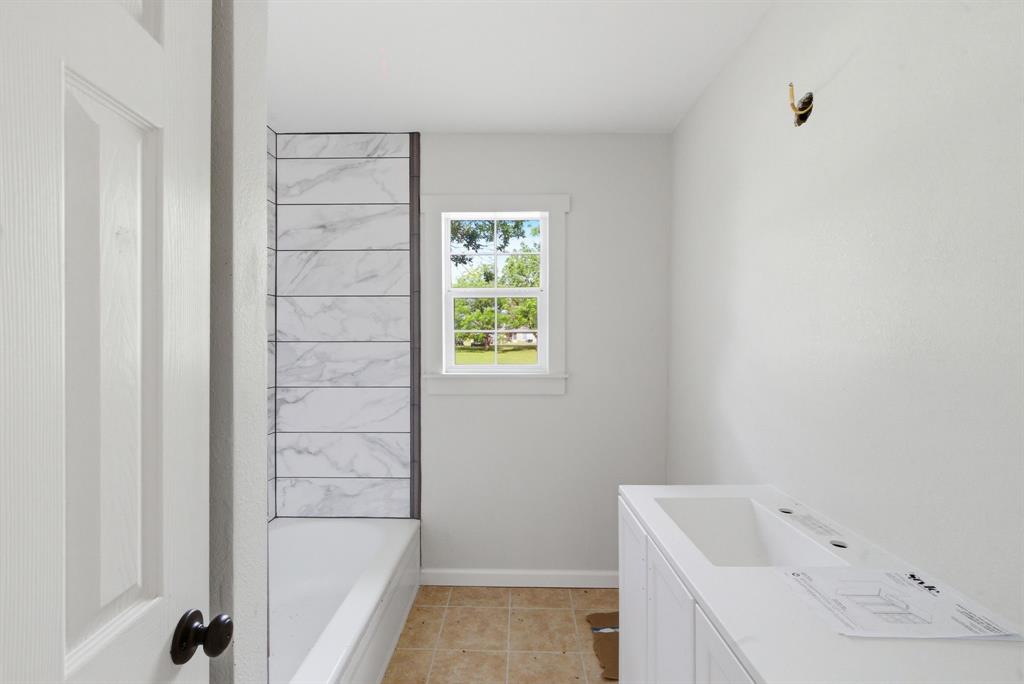 203 North Kickapoo Street Lipan, TX 76462 - Photo 16 of 28 a bathroom with a bathtub and shower