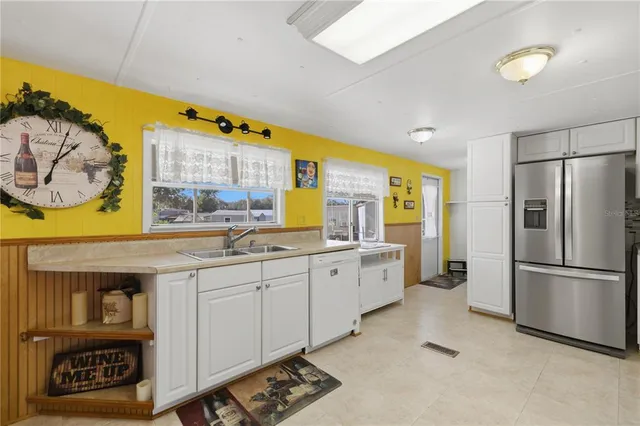 a kitchen with granite countertop a sink cabinets stainless steel appliances and a window