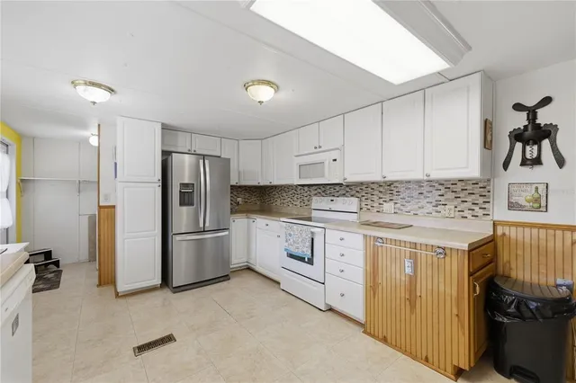 a kitchen with a refrigerator sink and cabinets