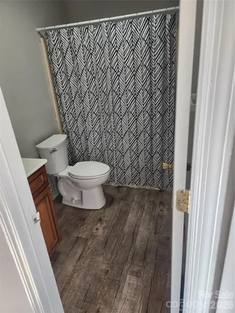 a bathroom with a toilet and a shower curtain