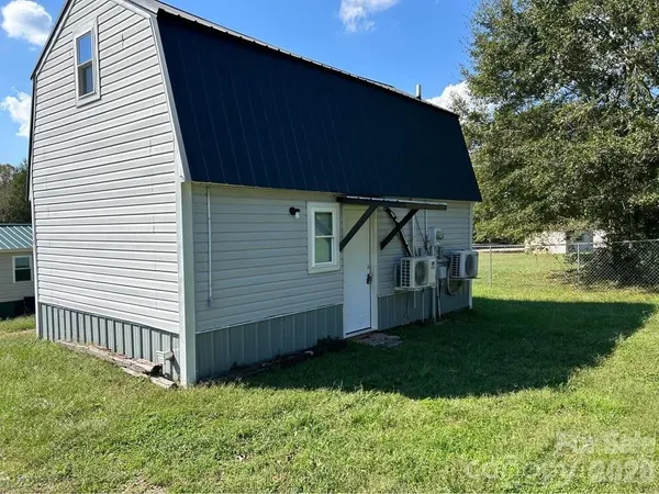 a view of backyard with small cabin and a chair