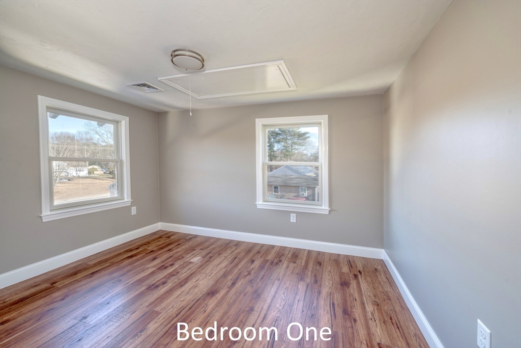 665 State Road, Unit 1 Plymouth, MA 02360 - Photo 11 of 13 a view of an empty room with wooden floor and a window