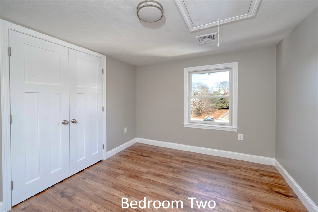 665 State Road, Unit 1 Plymouth, MA 02360 - Photo 12 of 13 a view of an empty room with wooden floor and a window