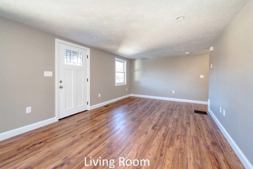 665 State Road, Unit 1 Plymouth, MA 02360 - Photo 8 of 13 wooden floor in an empty room with a window