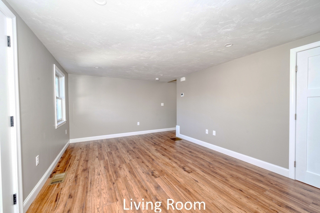 665 State Road, Unit 1 Plymouth, MA 02360 - Photo 9 of 13 a view of an empty room with wooden floor