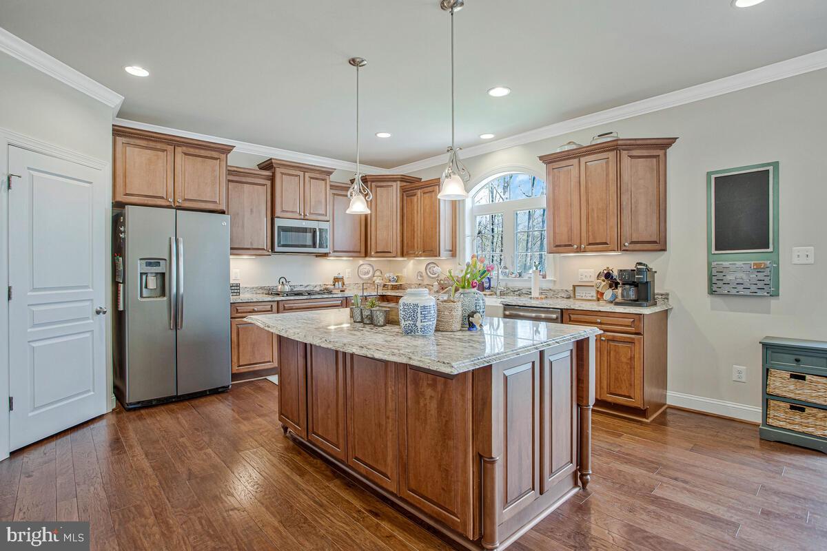 54 Simmons Ridge Road Prince Frederick, MD 20678 - Photo 19 of 55 a kitchen with kitchen island granite countertop a sink refrigerator and wooden floor