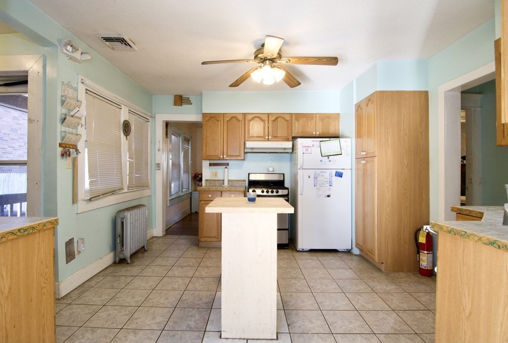 57 Bevier Street Springfield, MA 01107 - Photo 5 of 22 a kitchen with a refrigerator a stove top oven a sink dishwasher and wooden cabinets