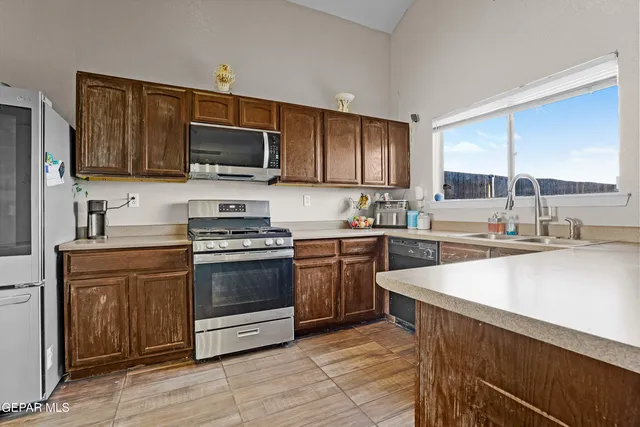 a kitchen with stainless steel appliances a stove sink microwave and cabinets