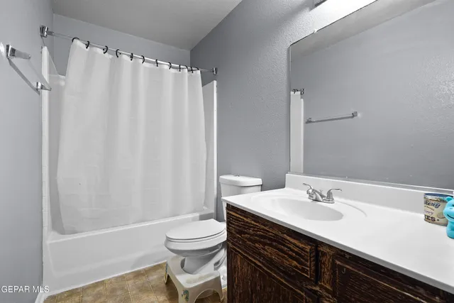a bathroom with a sink a toilet and shower curtain