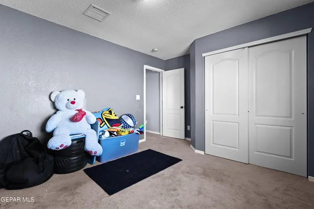 a bedroom with a bed and a computer on the table