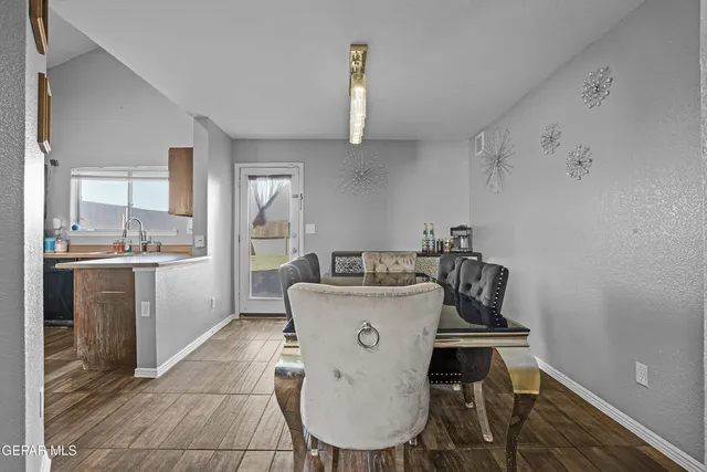 a kitchen with a table chairs refrigerator and cabinets