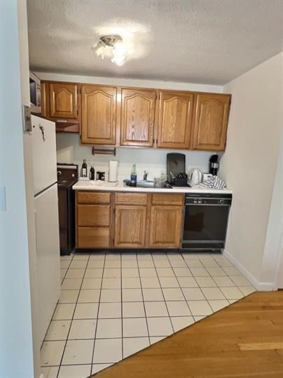 1039 Commonwealth Avenue, Unit 36 Boston, MA 02215 - Photo 2 of 6 a kitchen with stainless steel appliances a sink refrigerator and cabinets