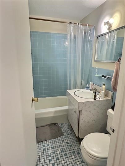 1039 Commonwealth Avenue, Unit 36 Boston, MA 02215 - Photo 5 of 6 a bathroom with a sink a toilet a mirror a bathtub and shower