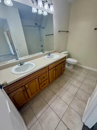 a spacious bathroom with a double vanity sink mirror and toilet