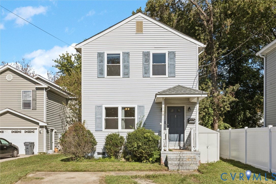 a view of a white house next to a yard with large trees
