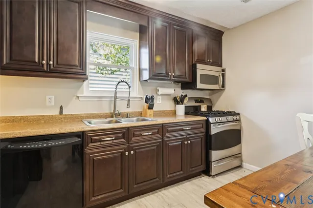 a kitchen with stainless steel appliances granite countertop a sink stove and cabinets