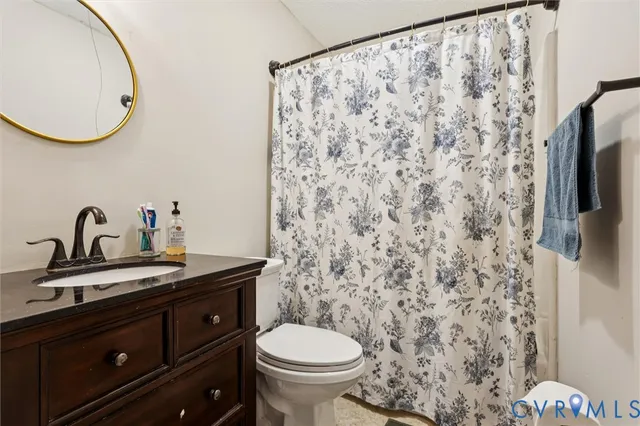 a bathroom with a granite countertop sink a toilet and a mirror
