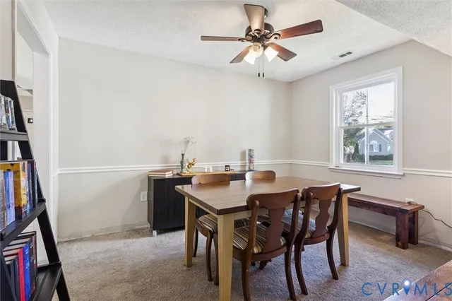 a view of a dining room with furniture and a chandelier fan