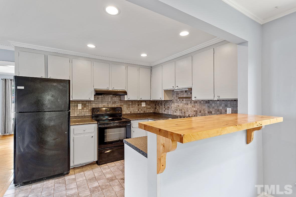 2727 Layden Street Raleigh, NC 27603 - Photo 15 of 23 a kitchen with a refrigerator a stove top oven a sink and cabinets
