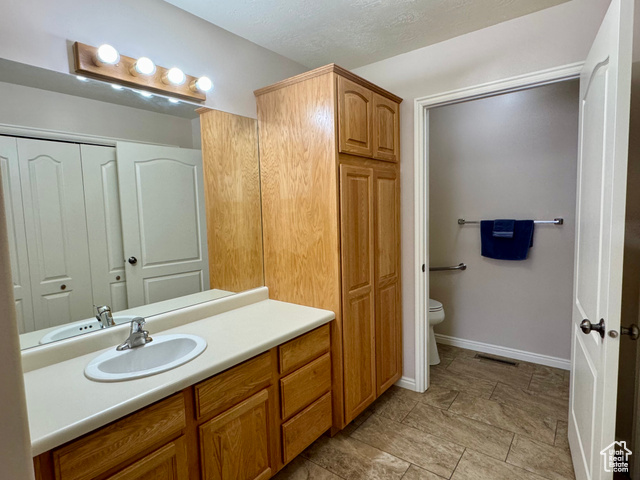 445 Topaz Boulevard, Unit 10 Delta, UT 84624 - Photo 12 of 28 Bathroom with vanity, toilet, a closet, and baseboards