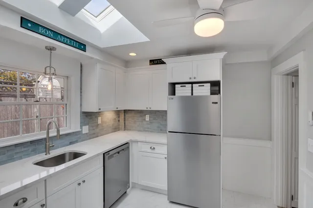 a kitchen with granite countertop a sink stainless steel appliances and cabinets