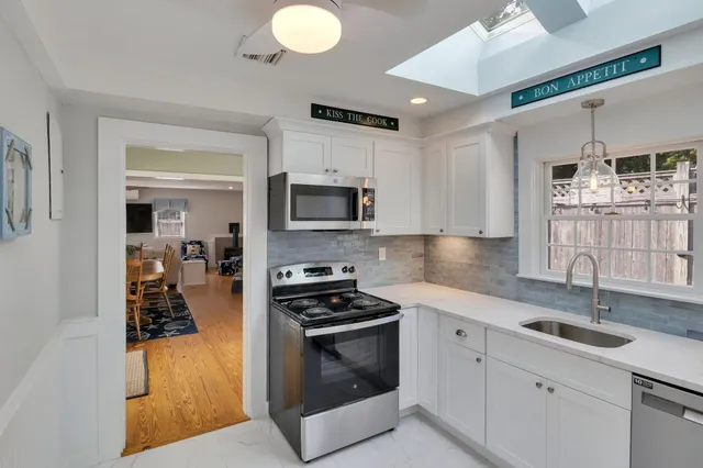a kitchen with kitchen island granite countertop a sink stainless steel appliances and cabinets
