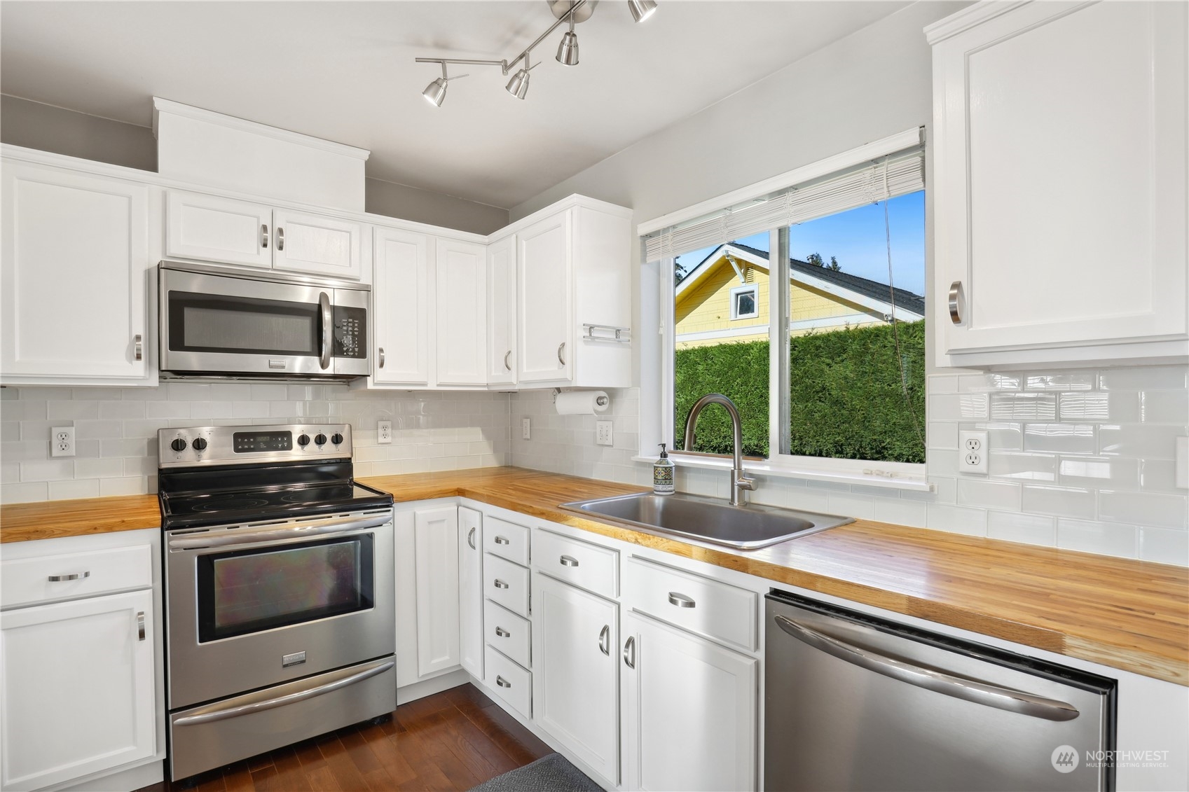 2028 Northeast 12th Street Renton, WA 98056 - Photo 8 of 40 a kitchen with stainless steel appliances white cabinets and a stove top oven