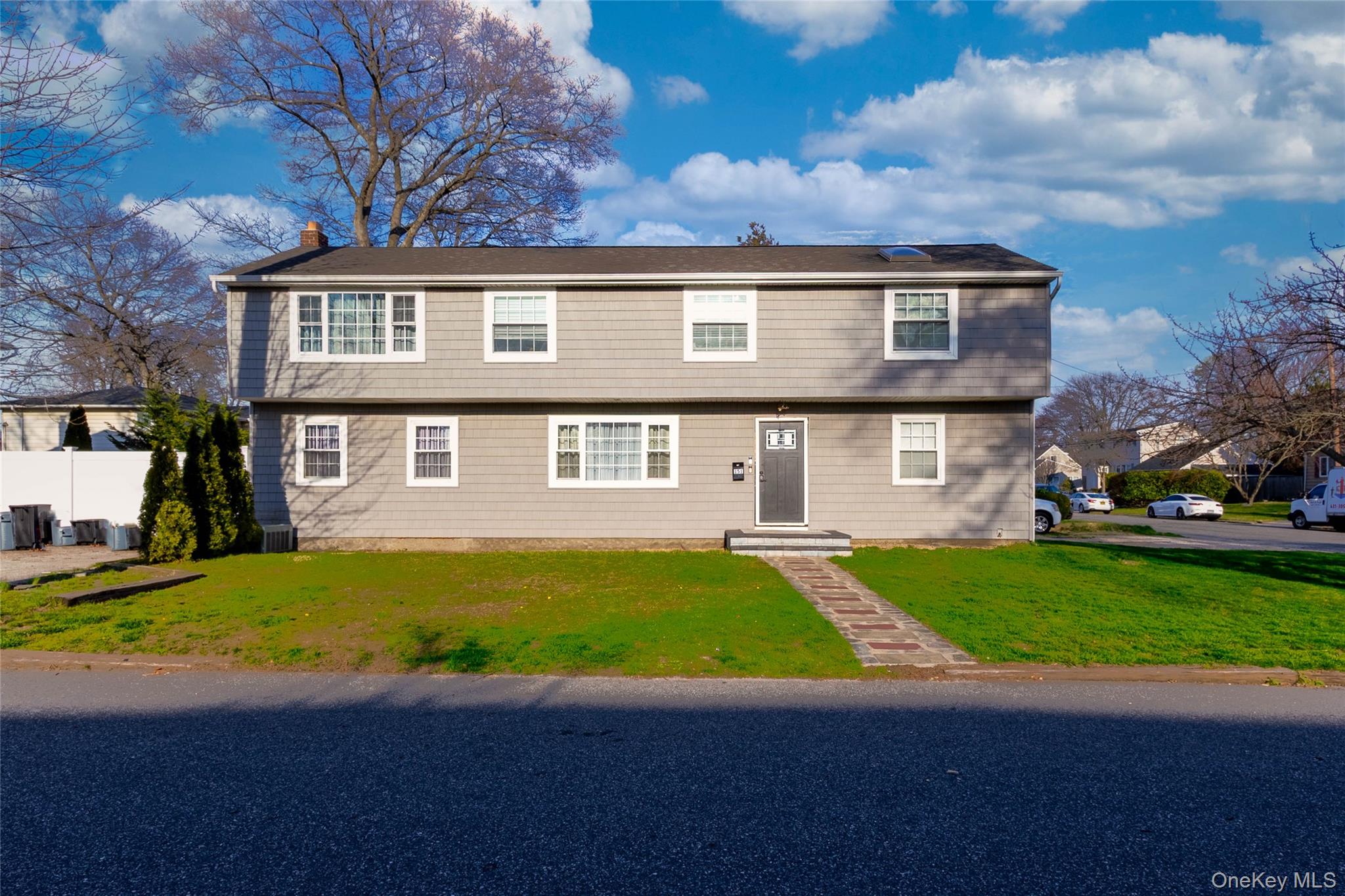 The property features a two-story exterior with light gray siding and white-trimmed windows