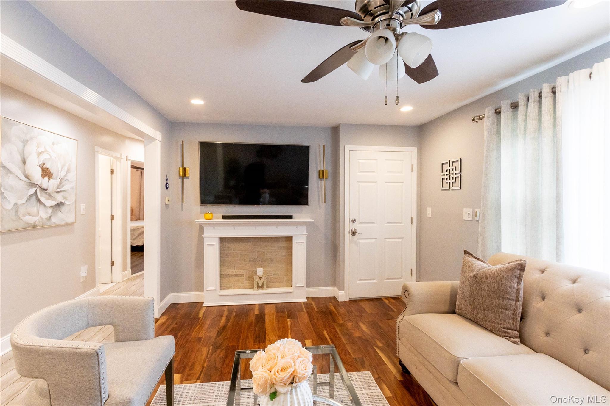 151 Cheltenham Road West Babylon, NY 11704 - Photo 16 of 42 Living area featuring wood-finish flooring, a decorative fireplace mantel with a tile surround, and recessed lighting
