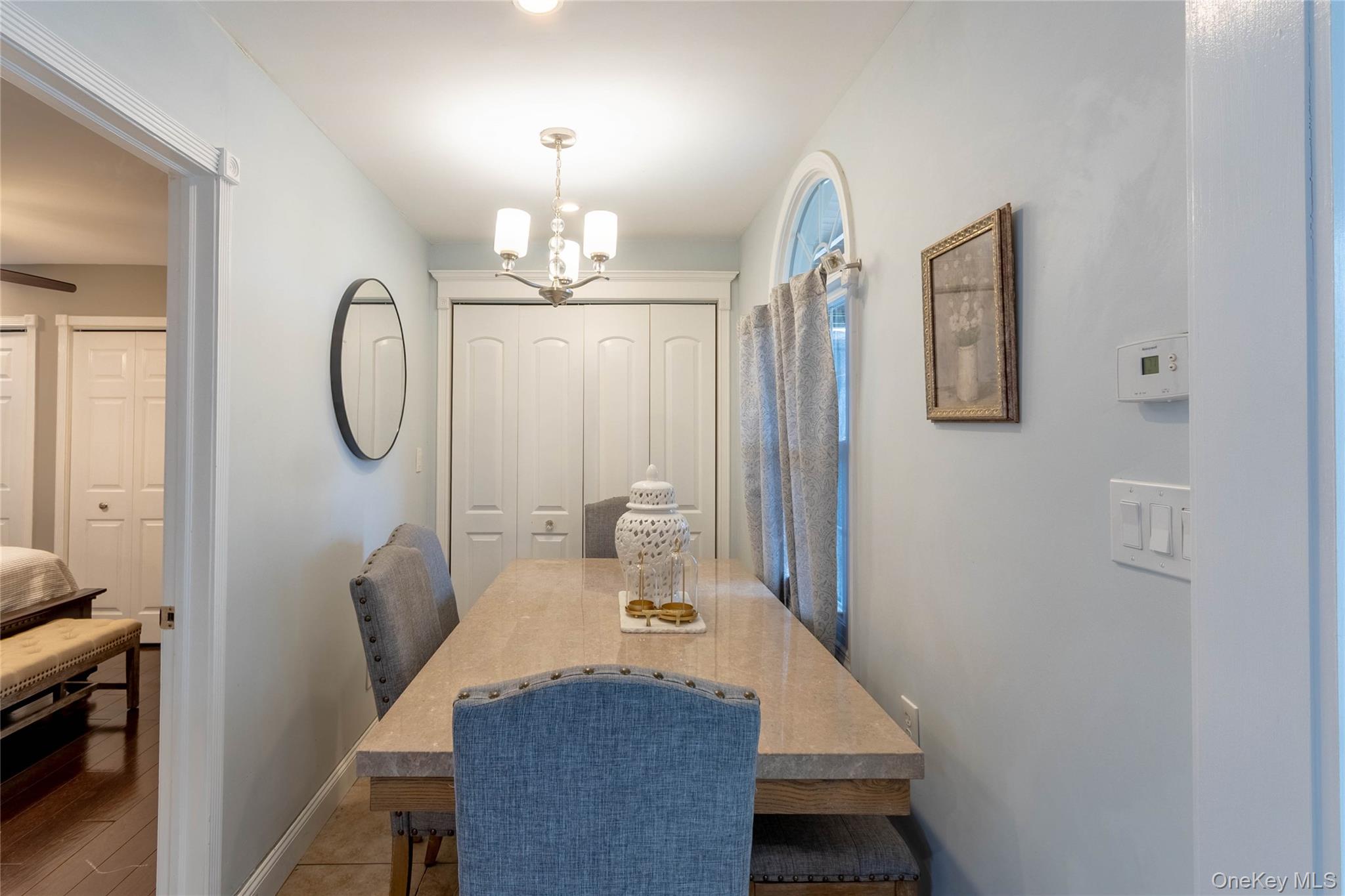 151 Cheltenham Road West Babylon, NY 11704 - Photo 20 of 42 Dining area featuring a contemporary chandelier, arched window, and bi-fold closet doors