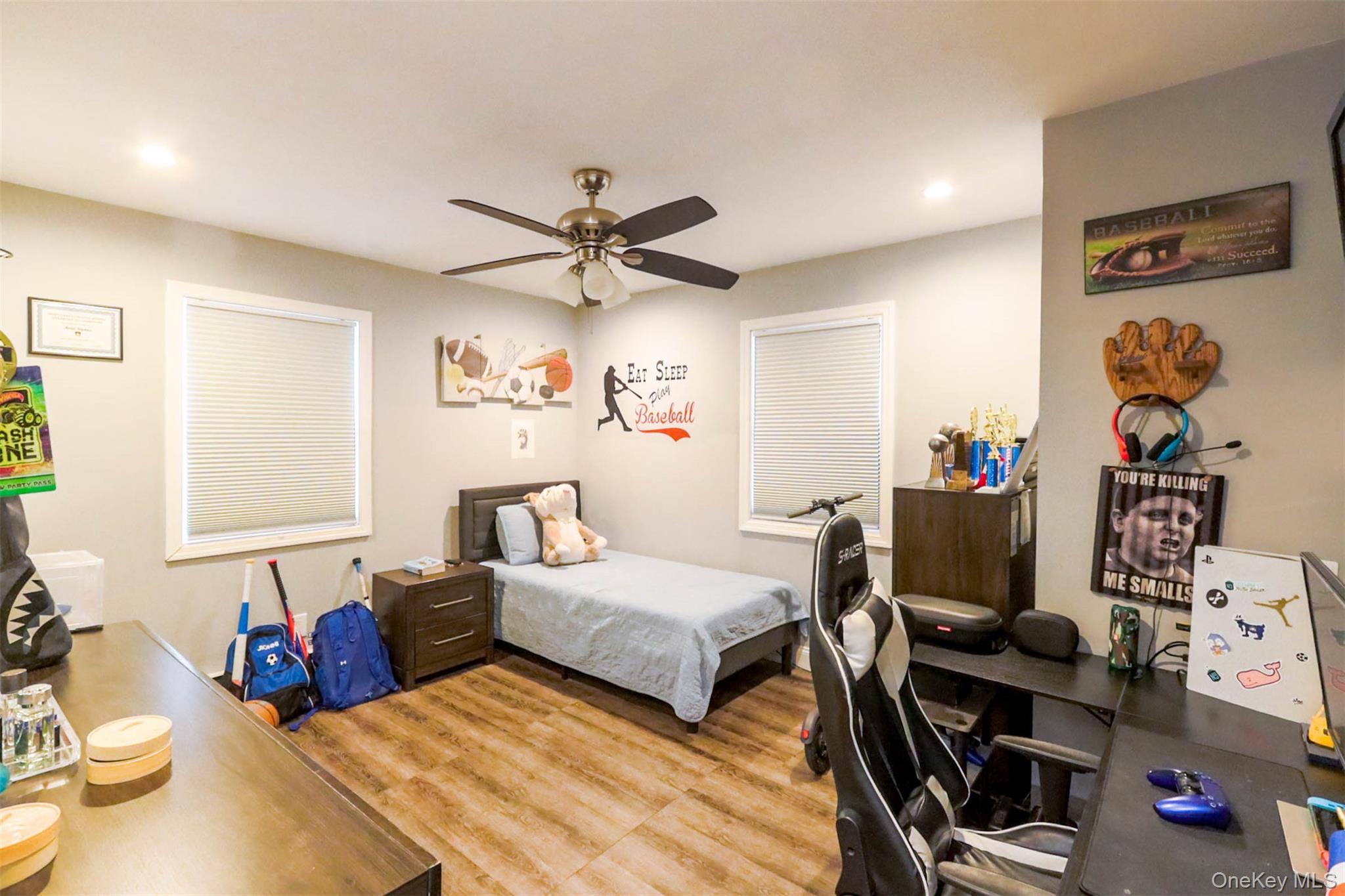 151 Cheltenham Road West Babylon, NY 11704 - Photo 21 of 42 Spacious room featuring wood-finish flooring, two windows with blinds, a ceiling fan with integrated lighting, and recessed lighting