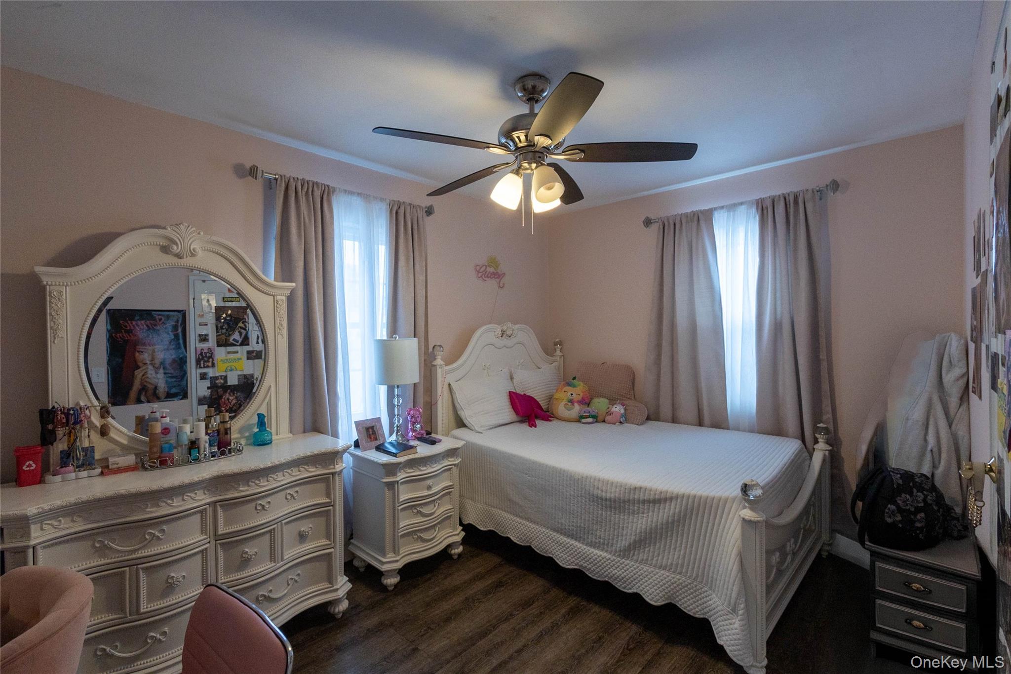 151 Cheltenham Road West Babylon, NY 11704 - Photo 22 of 42 Room featuring wood-finish flooring, a ceiling fan with integrated lighting, and two windows with opaque privacy curtains