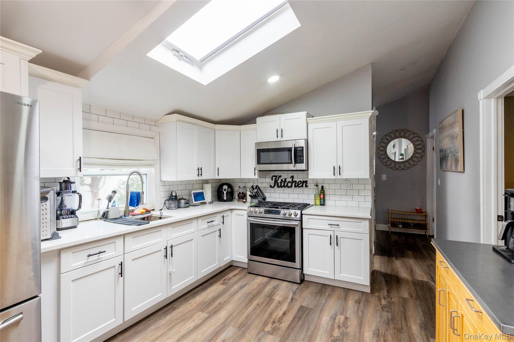 151 Cheltenham Road West Babylon, NY 11704 - Photo 29 of 42 Modern kitchen featuring a skylight and wood-finish flooring