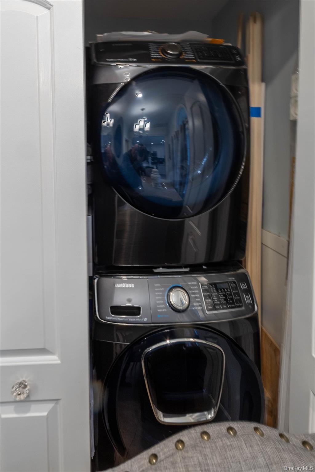 151 Cheltenham Road West Babylon, NY 11704 - Photo 34 of 42 Stacked front-load washer and dryer set, featuring a dark finish and visible controls