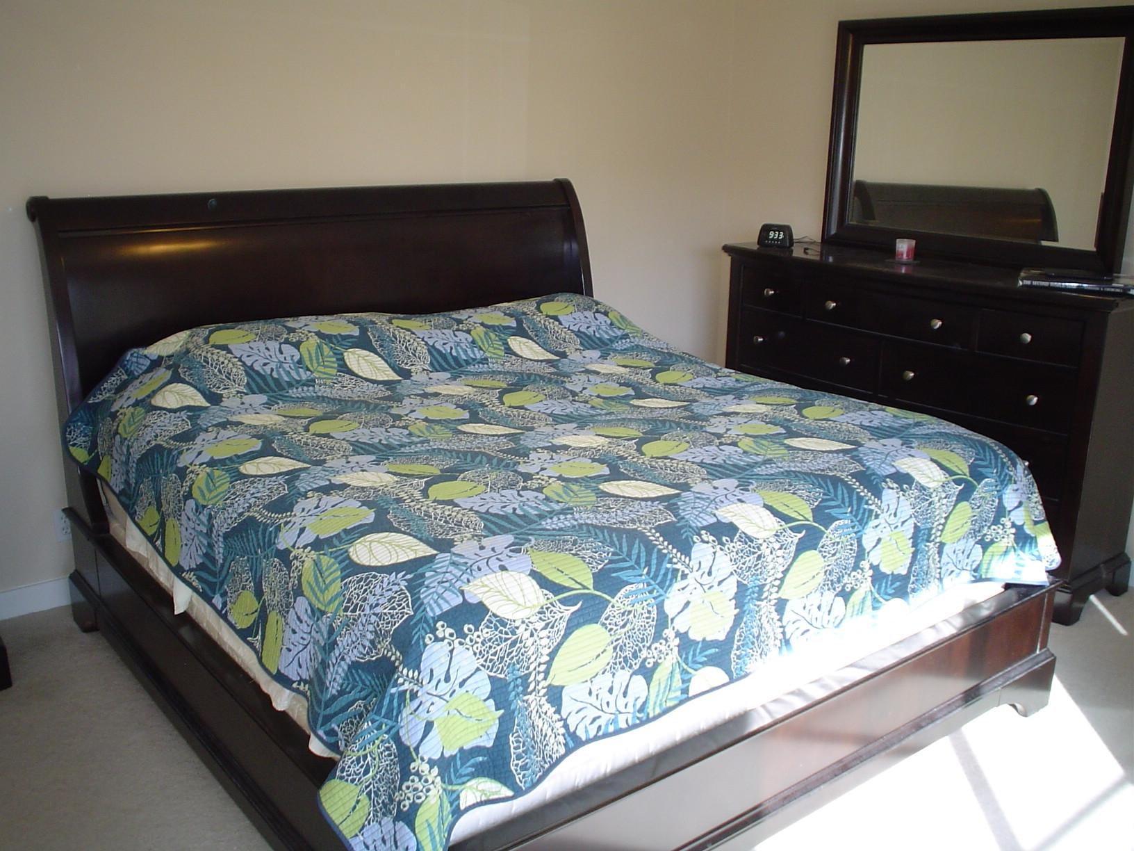 1445 Masters Circle, Unit 157 Delray Beach, FL 33445 - Photo 22 of 23 a bedroom with a bed and a mirror on dresser