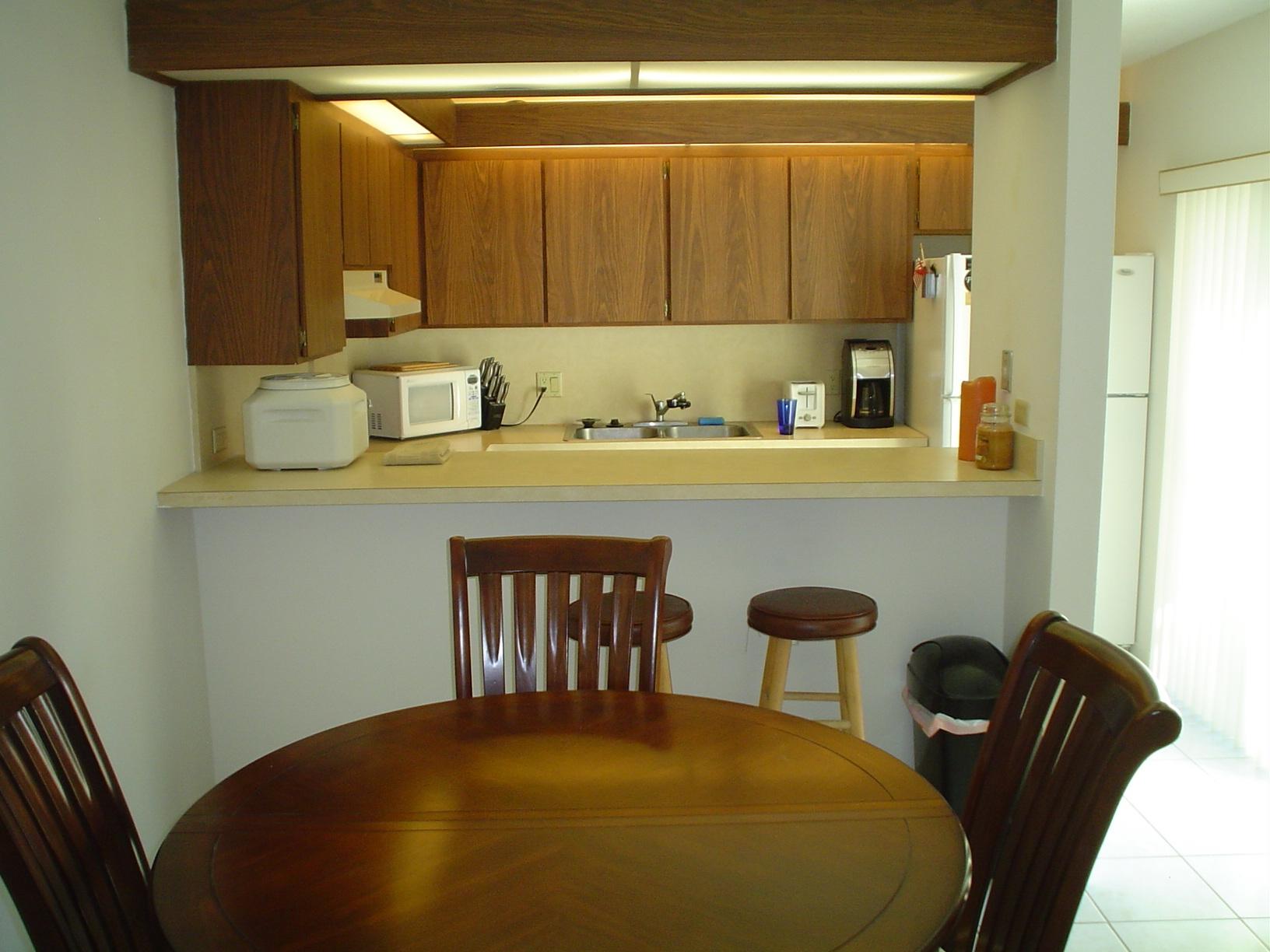 1445 Masters Circle, Unit 157 Delray Beach, FL 33445 - Photo 9 of 23 a kitchen with a table chairs and front door