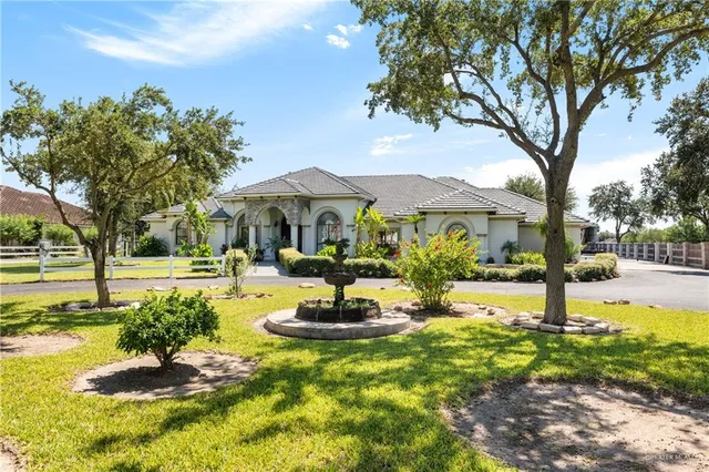 a front view of a house with swimming pool and trees