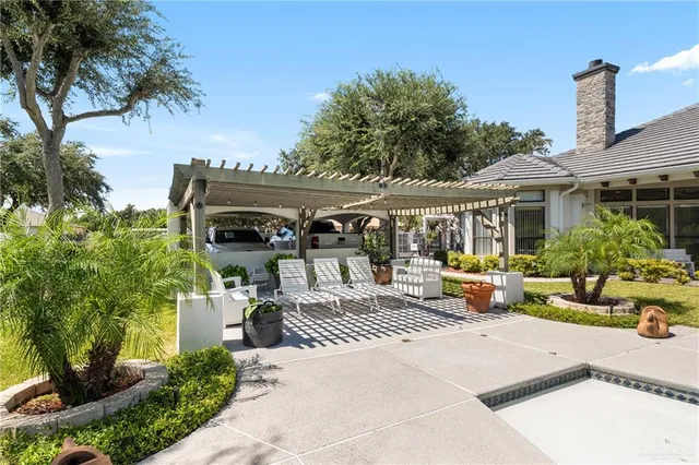 a view of a patio with table and chairs potted plants and palm tree