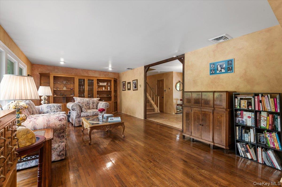 6 Apex Road Melville, NY 11747 - Photo 5 of 50 a living room with furniture and a book shelf