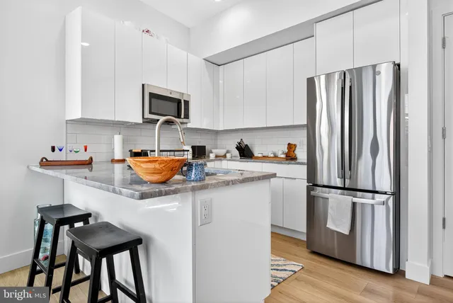 a kitchen with stainless steel appliances granite countertop a refrigerator and a stove top oven