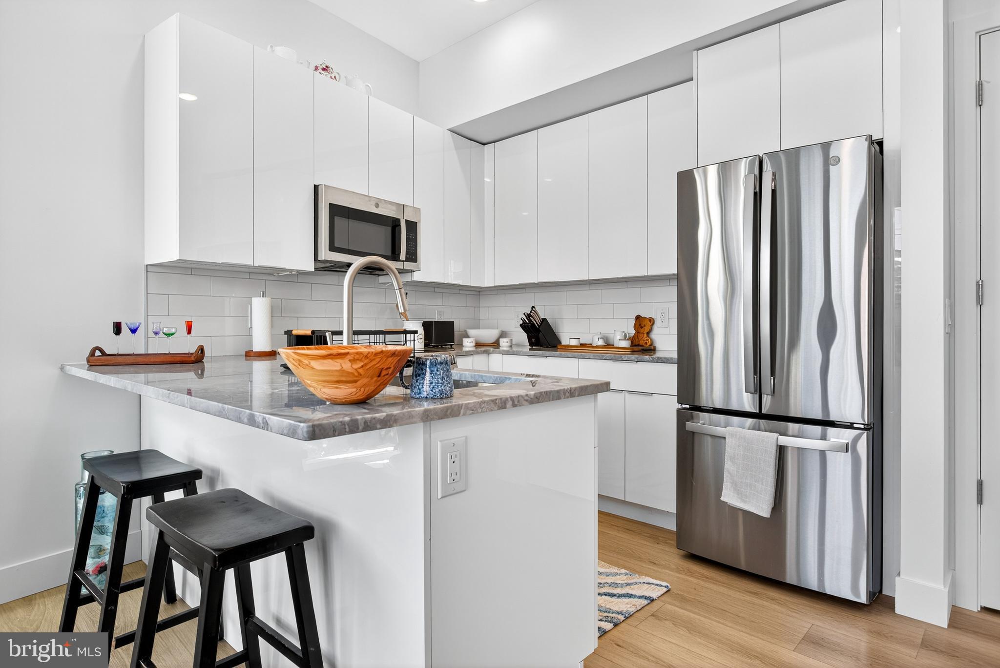 300 Christian Street, Unit 311 Philadelphia, PA 19147 - Photo 5 of 30 a kitchen with stainless steel appliances granite countertop a refrigerator and a stove top oven